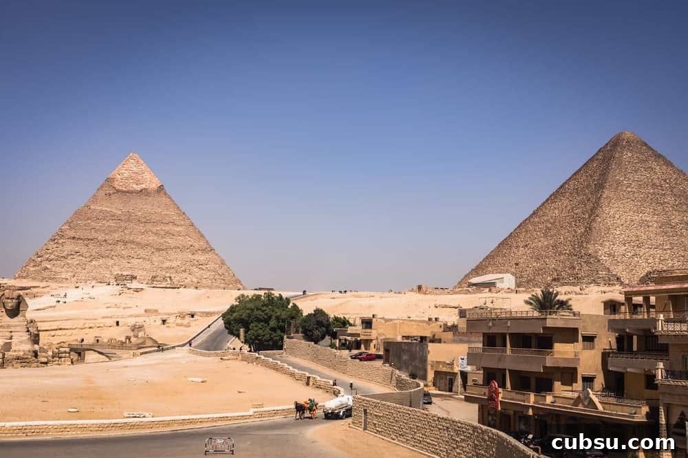 Cairo Adventures: Top Experiences and Hidden Gems to Explore 2 View of the Pyramids with a road with people, carts, and camels.