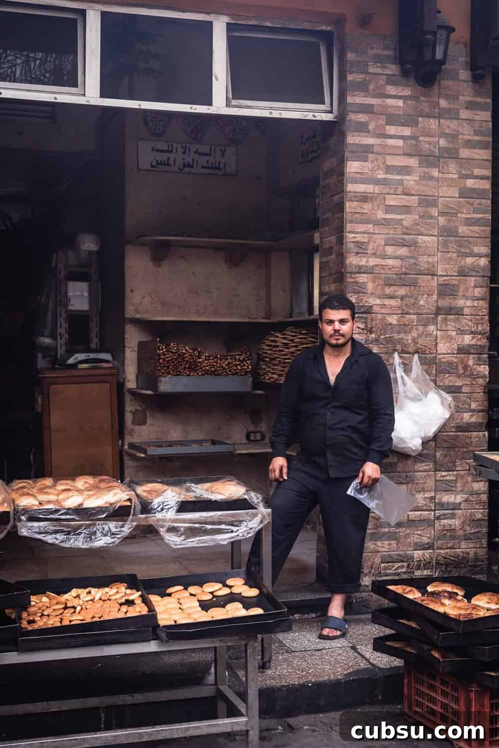 Cairo Adventures: Top Experiences and Hidden Gems to Explore 11 Bakery in Old Cairo, portrait shot of store owner posing with a serious face in front if his baked goods.