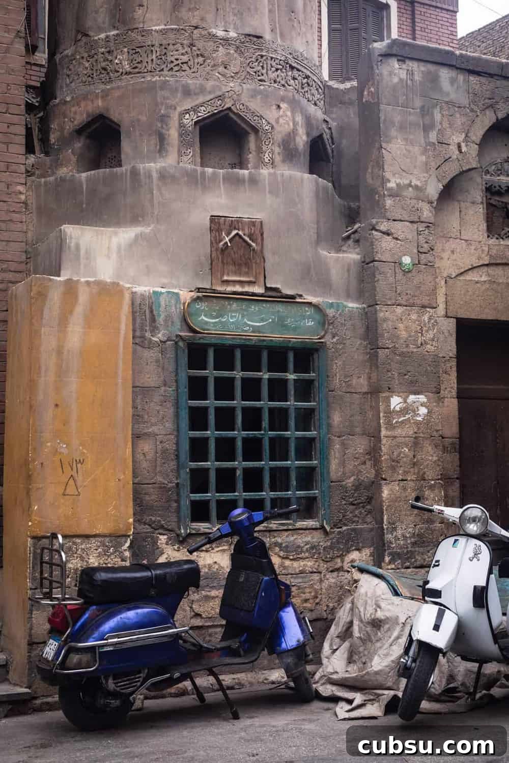 Cairo Adventures: Top Experiences and Hidden Gems to Explore 7 2 motorcycles parked outside an incredibly old building in Old Cairo.