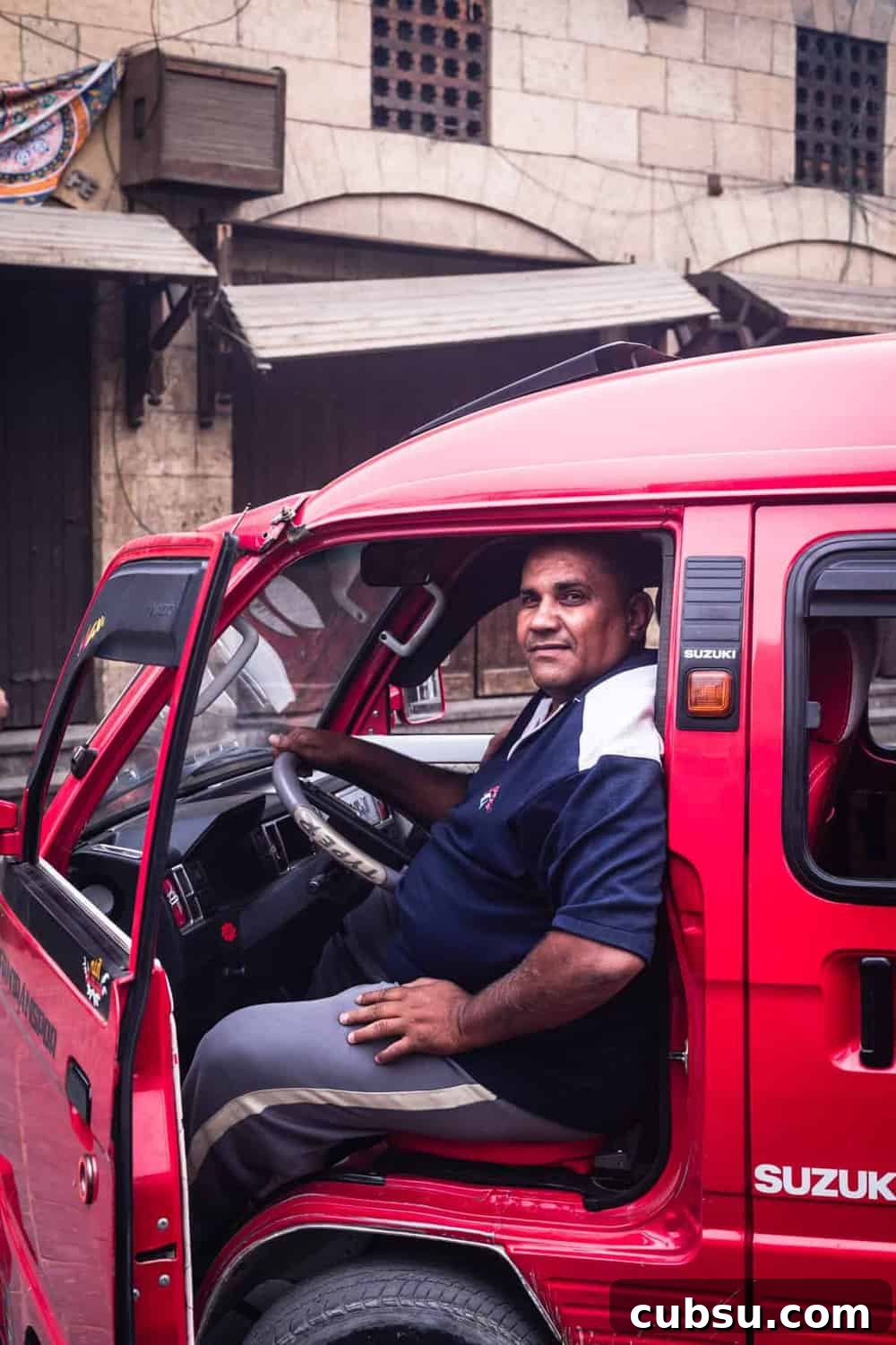 Cairo Adventures: Top Experiences and Hidden Gems to Explore 9 portrait shot of a man sitting in a red trunk, posing for my camera in Old Cairo.