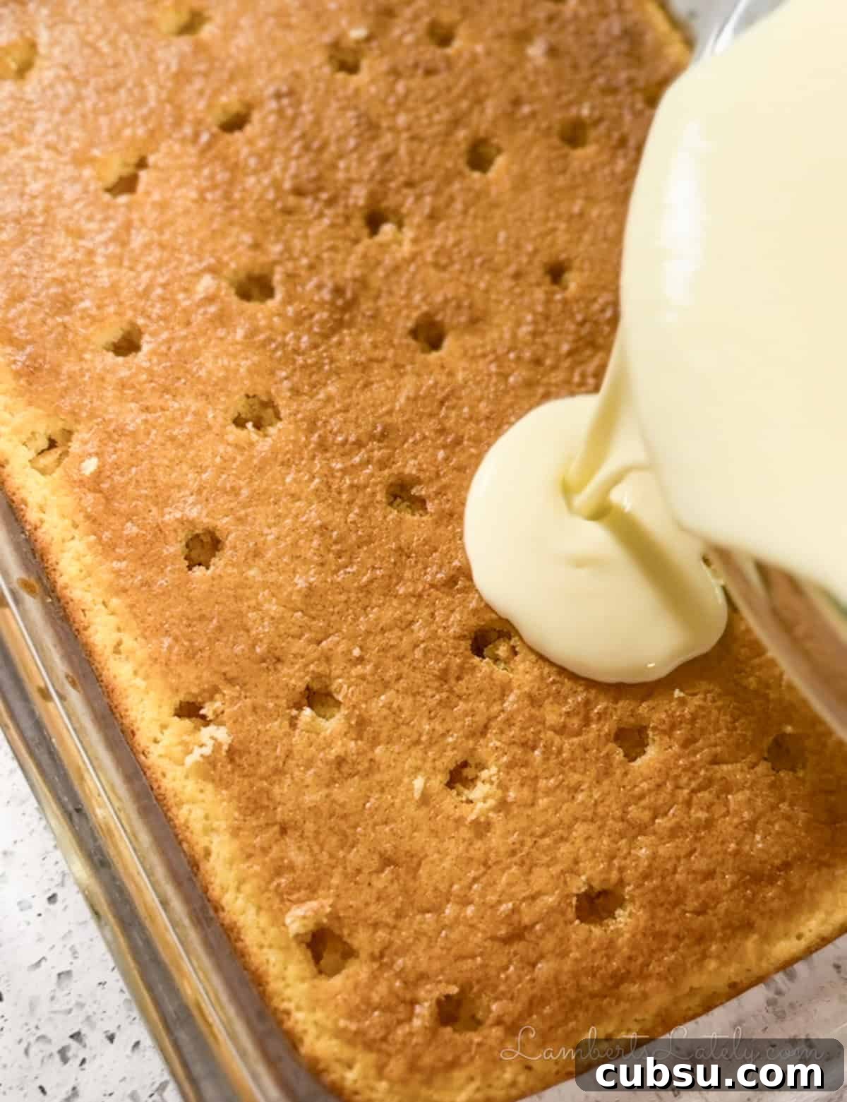 pouring pudding mixture over cake with holes.