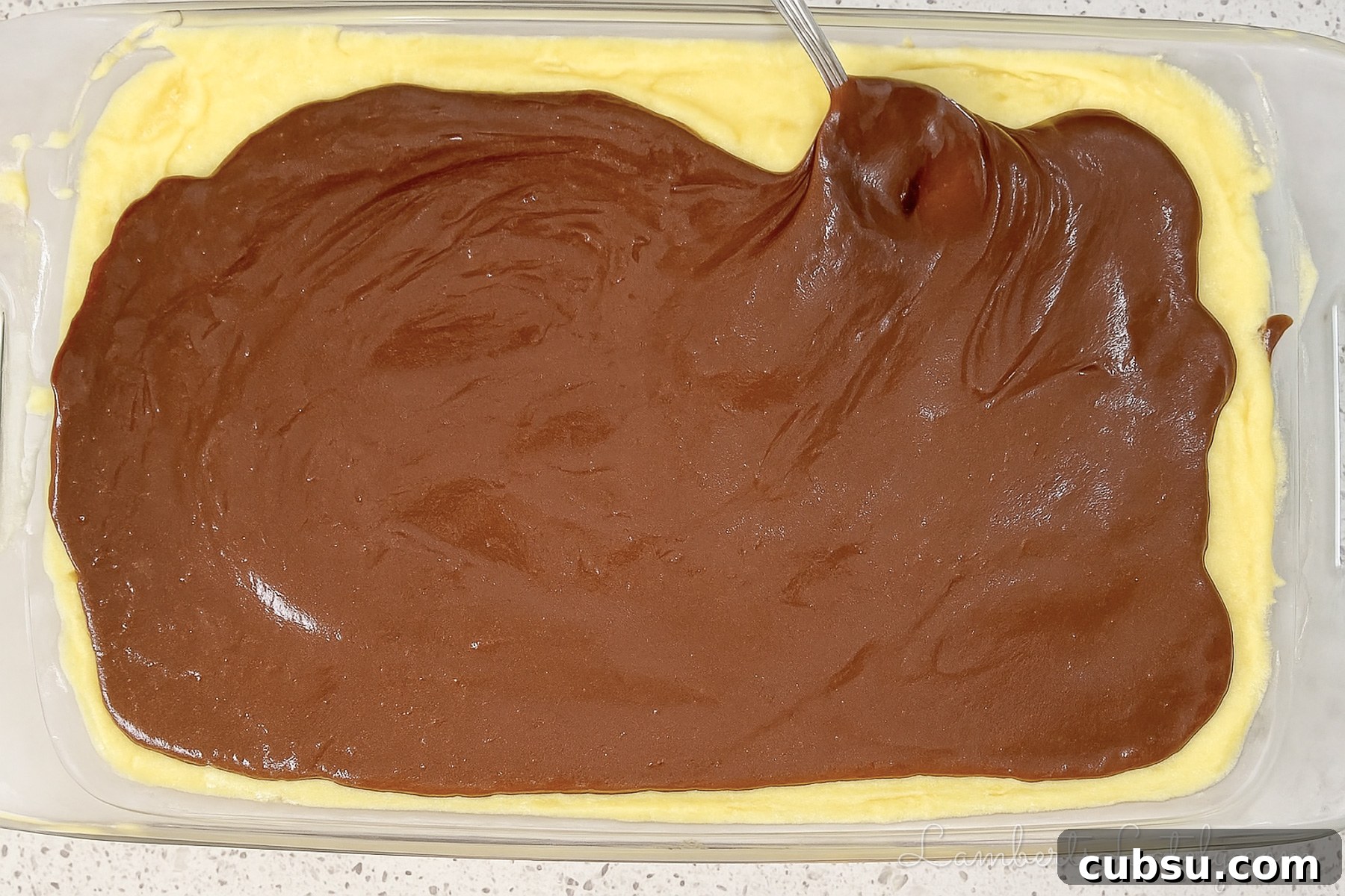 spreading chocolate ganache over pudding layer.