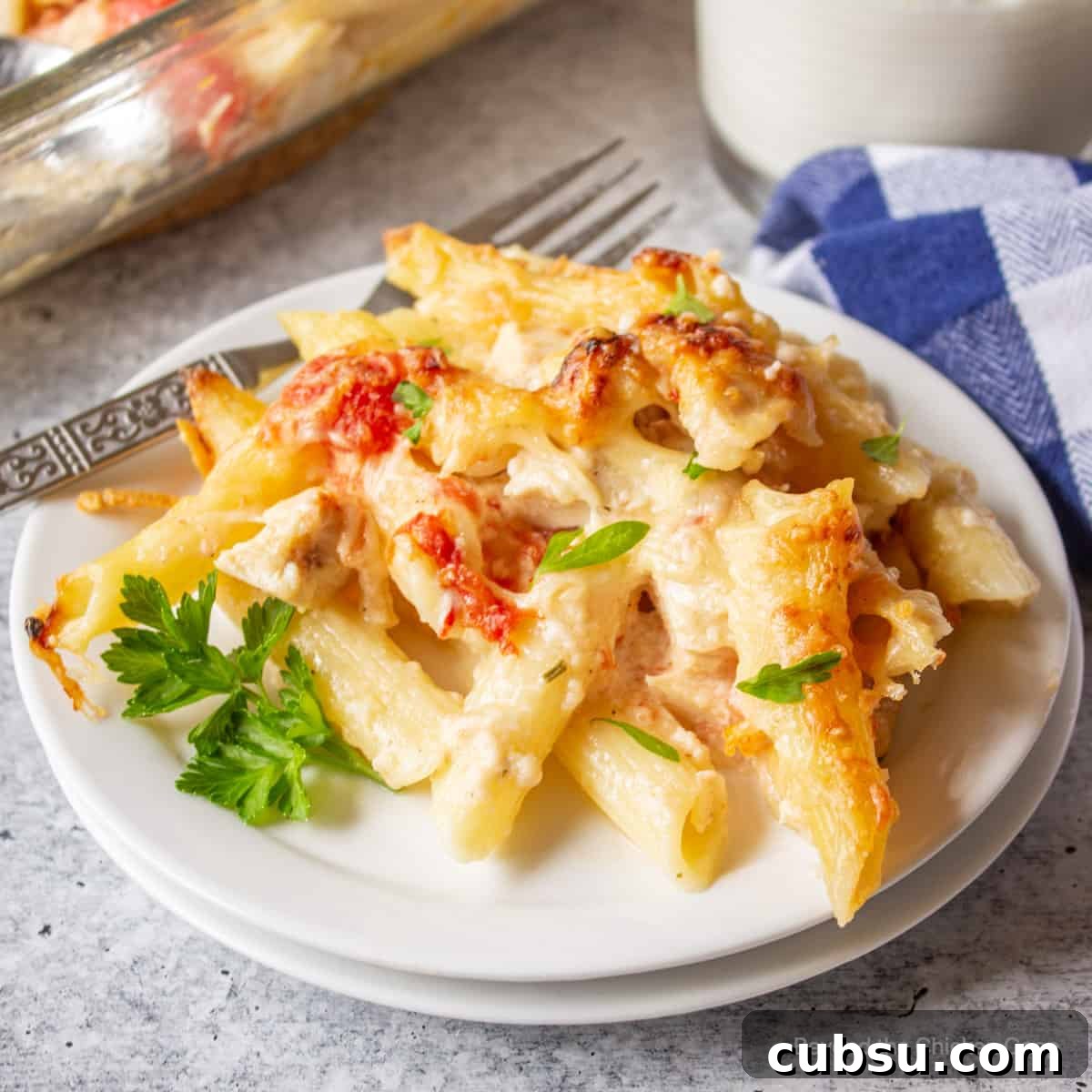 A portion of chicken pasta bake on a white plate. 