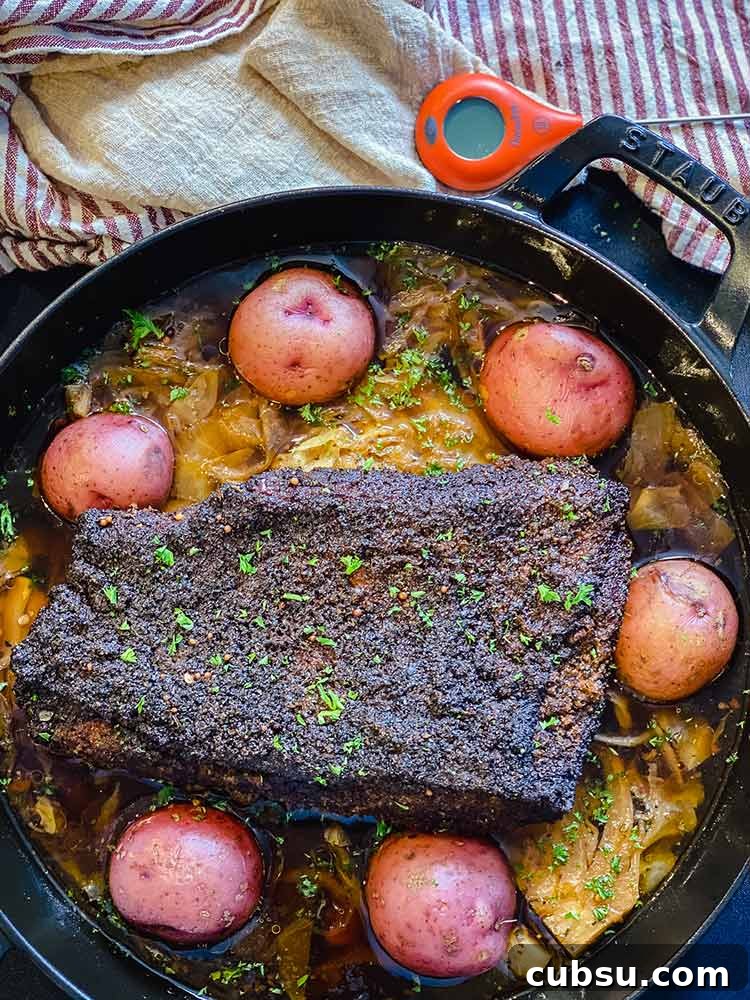 Smoked and Beer-Braised Corned Beef Recipe for Tender, Flavorful Meat 11 whole red potatoes added to cast iron pan containing beer-braised corned beef and cabbage
