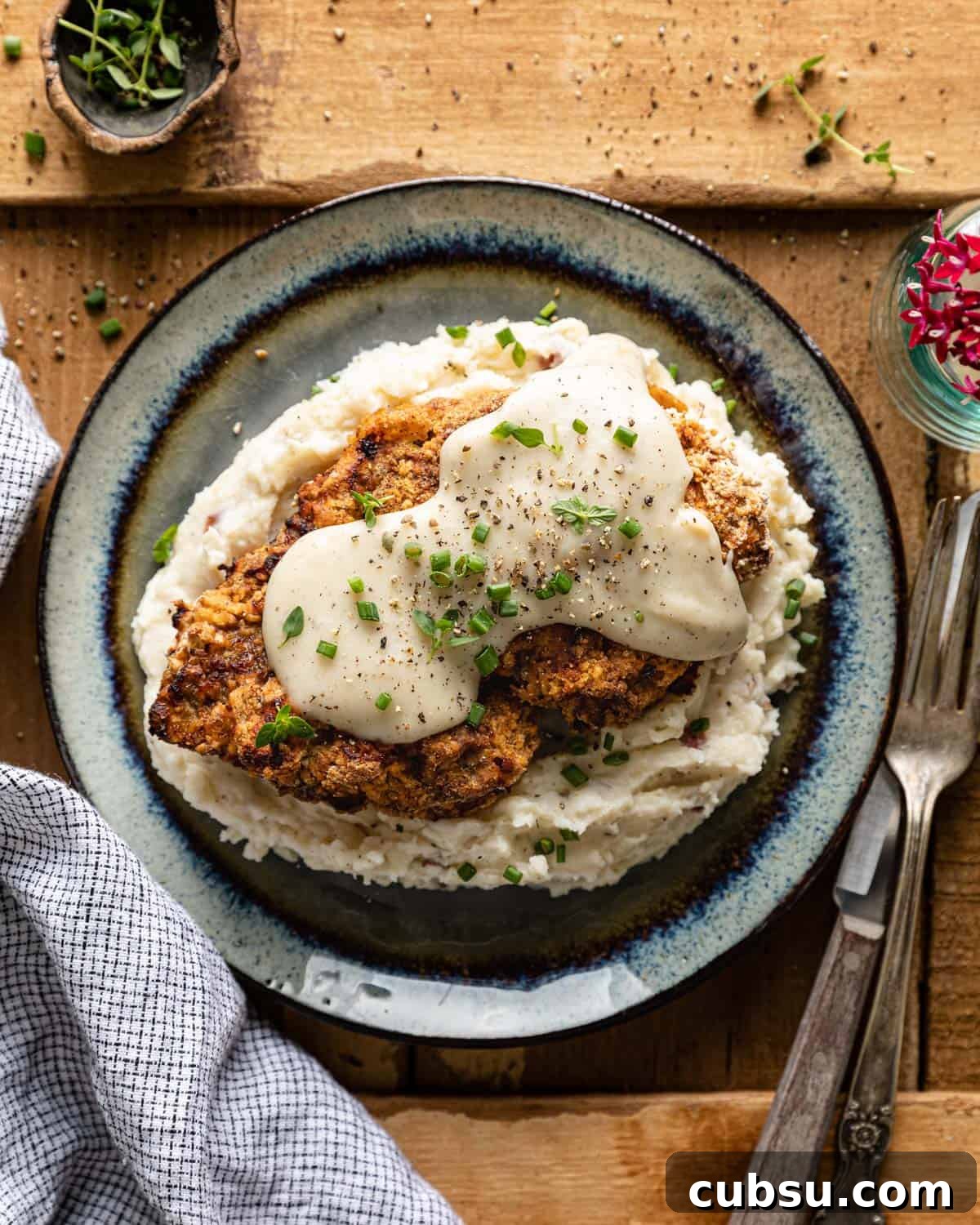 Air fryer chicken fried steak on a bed of mashed potatoes. 