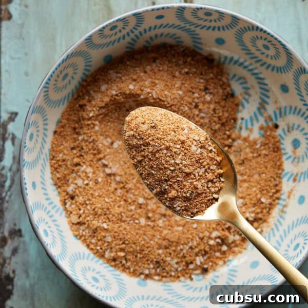 Bowl of burger seasoning with a gold spoon.
