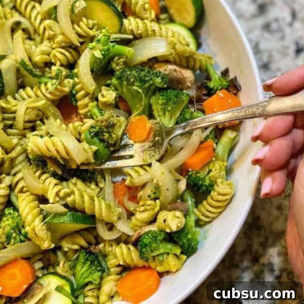 Vegan Pesto Pasta Recipe Vegan pesto pasta recipe in a bowl. I am eating it with a fork.