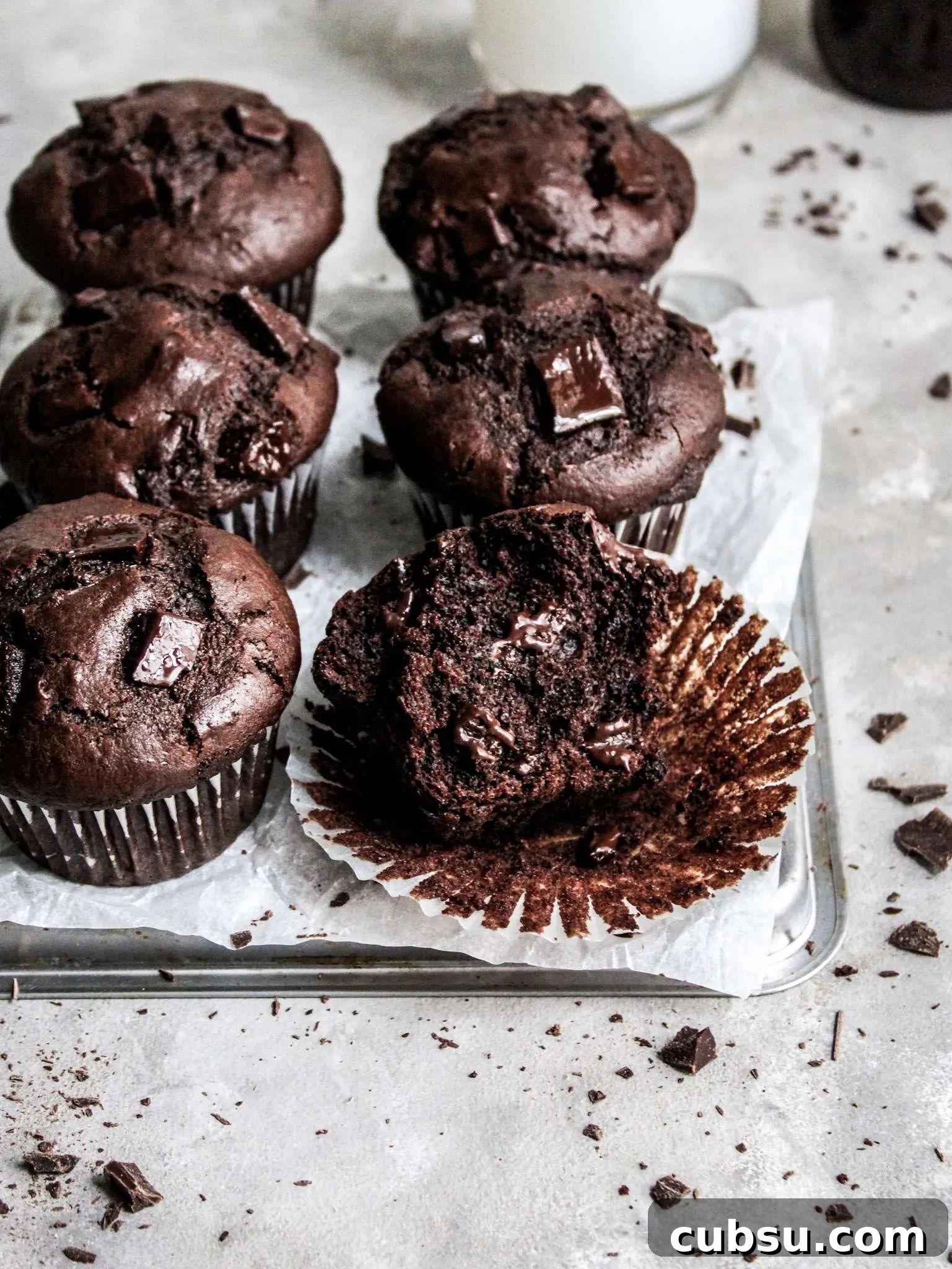 Muffins vs Cupcakes: Key Differences, Taste & Baking Tips 2 double chocolate chip muffins on serving dish three quarter angle (4)