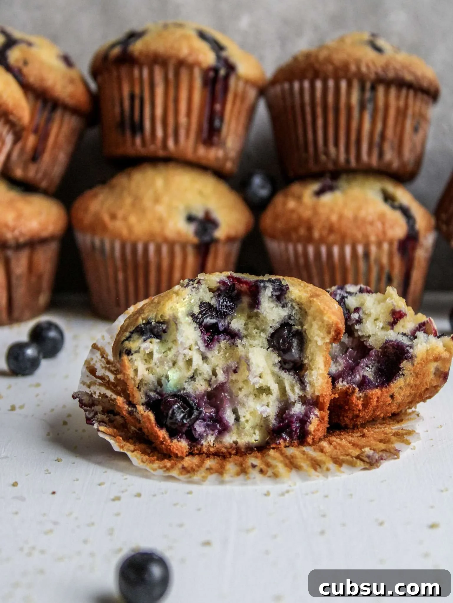 Muffins vs Cupcakes: Key Differences, Taste & Baking Tips 6 blueberry muffin split in half on table