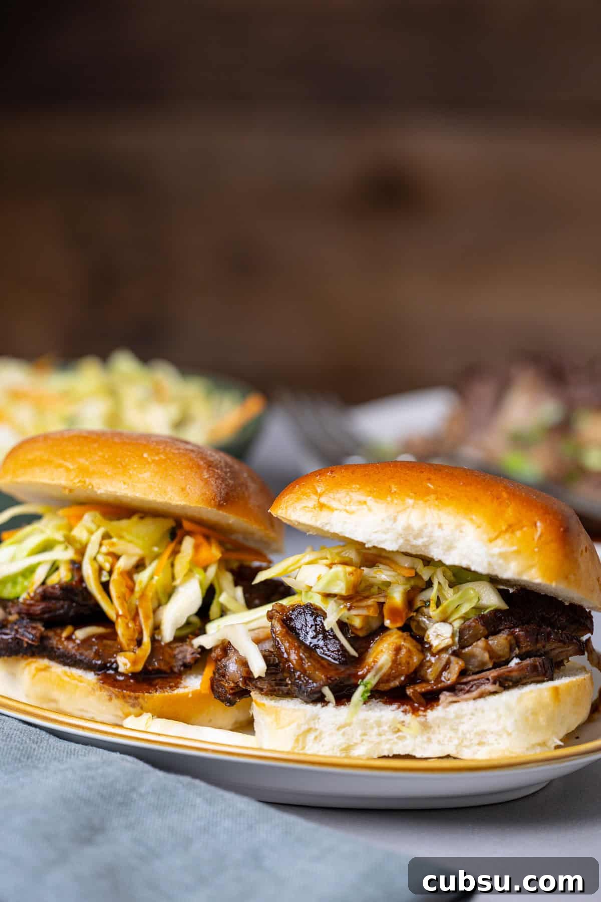 Citrus Slaw Braised Beef Sliders – Tangy Gourmet Sandwiches 11 Two braised beef sliders topped with citrus slaw.