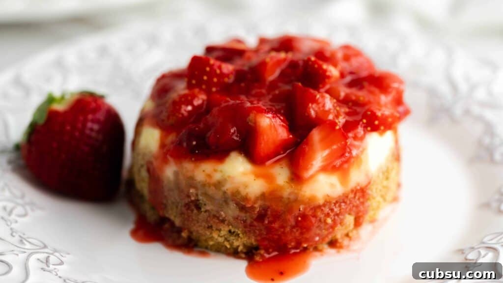 Instant Pot Strawberry Cheesecake Recipe — Creamy One-Pot Dessert 5 Decorative plate with a cheesecake sitting on it topped with strawberries.