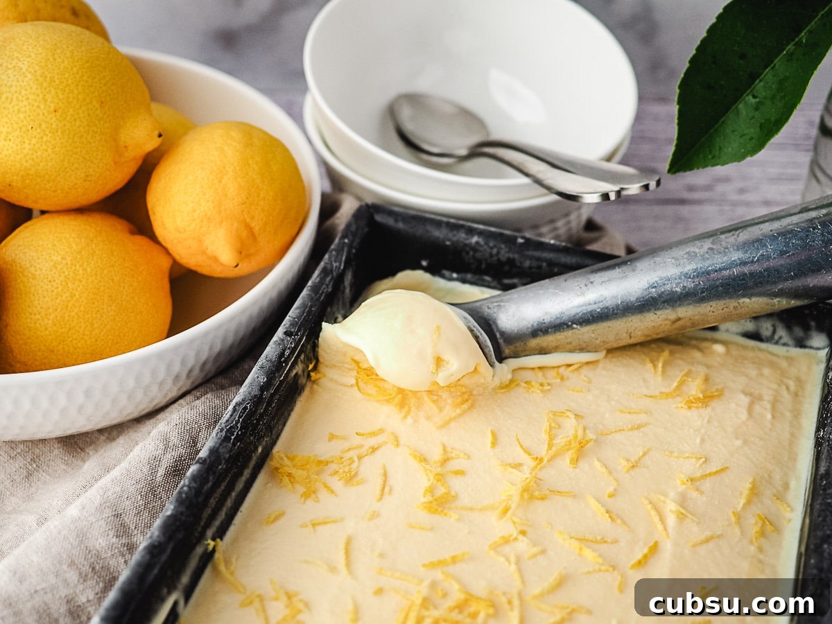 Creamy Lemon Ice Cream Recipe: Bright, Tangy Homemade Treat 3 Scooping ice cream from a pan, with bowl of spoons and fresh lemons in background.