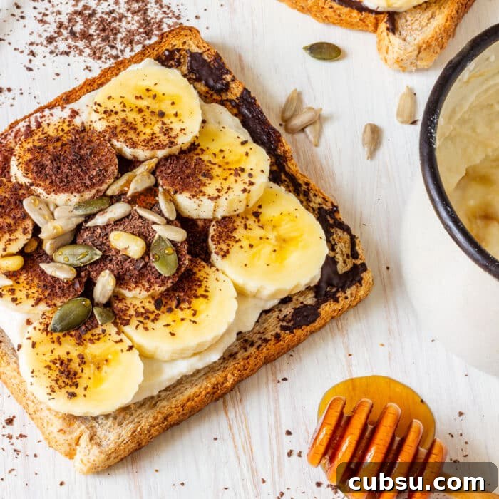 Quick After-School Snack Ideas Kids Will Love 8 Breakfast banana toast with toppings, next to a cup and honey dipper.