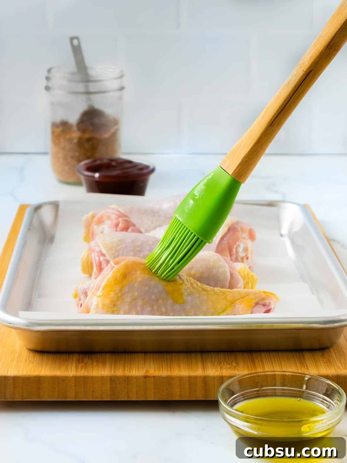 Brushing the chicken legs with oil.