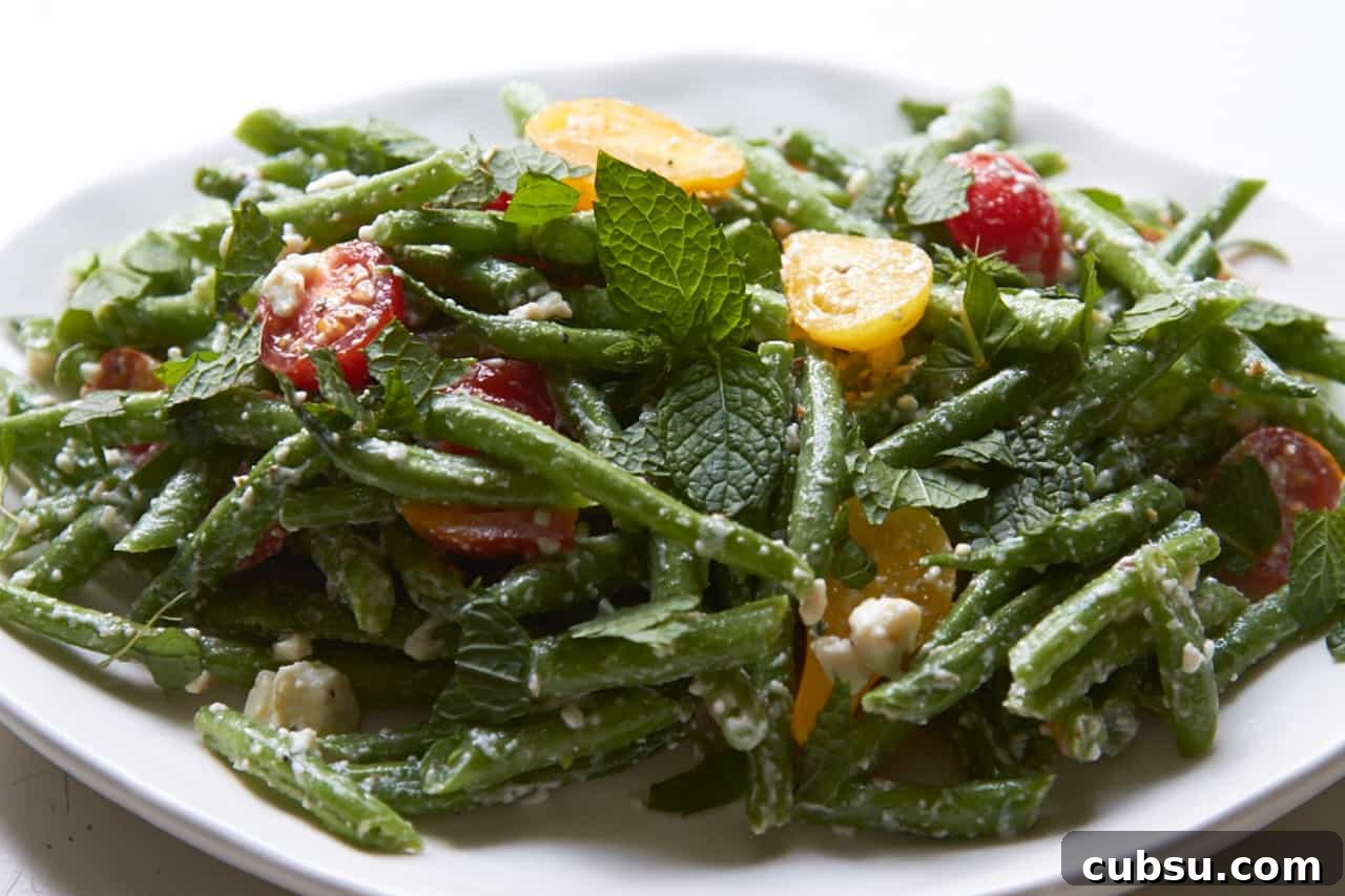 Mediterranean Green Bean Salad with Tomatoes, Feta & Mint 6 Green bean salad with feta and mint on a white plate.