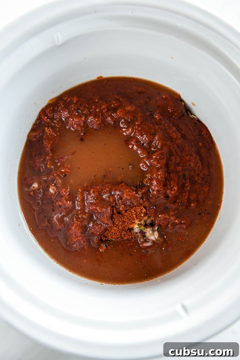 slow cooker with crushed tomatoes and broth