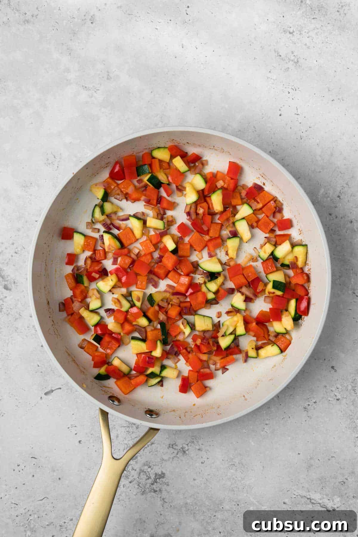 Make-Ahead Breakfast Burritos for Busy Mornings 6 overhead view of cooked vegetables for breakfast burritos in a skillet.
