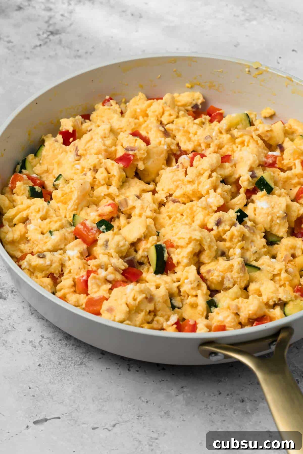 Make-Ahead Breakfast Burritos for Busy Mornings 7 side view of a veggie egg scramble for breakfast burritos in a skillet.