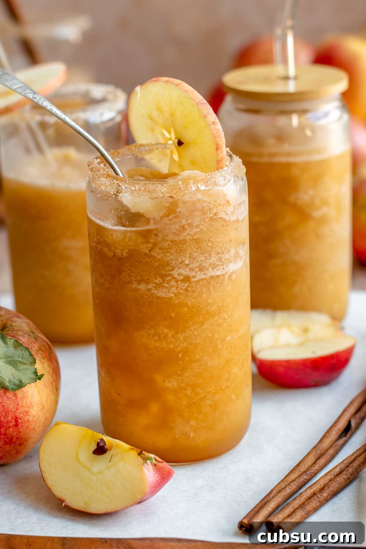 Spiced Apple Cider Slushies — Boozy or Virgin Recipes for Fall 2 Apple cider slushie in glasses with straws.