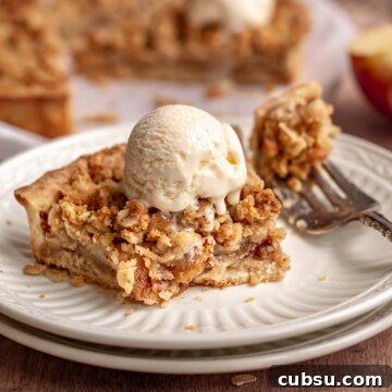 Apple crumble tart on a plate with a scoot of ice cream on top.