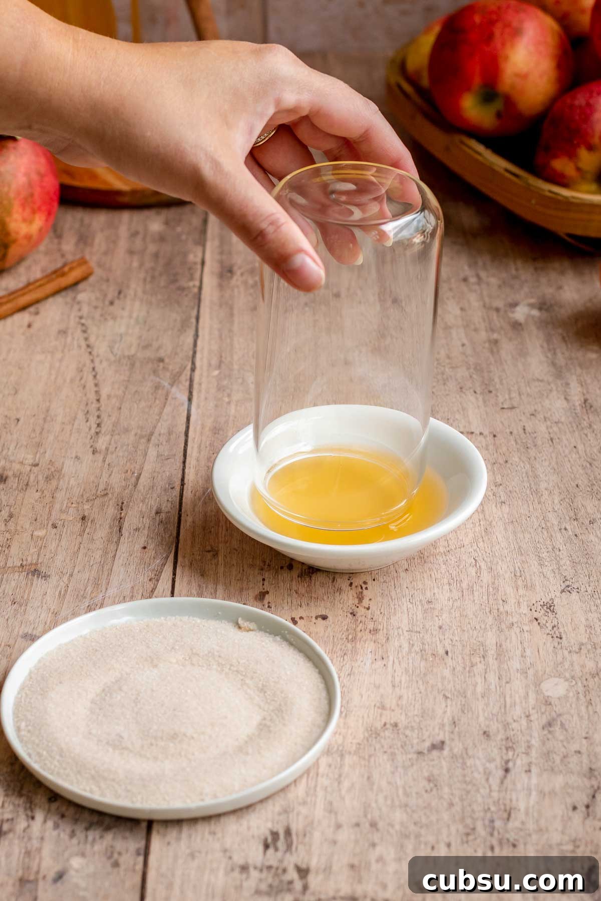 Spiced Apple Cider Slushies — Boozy or Virgin Recipes for Fall 5 A hand dips the rim of a glass off into apple cider.
