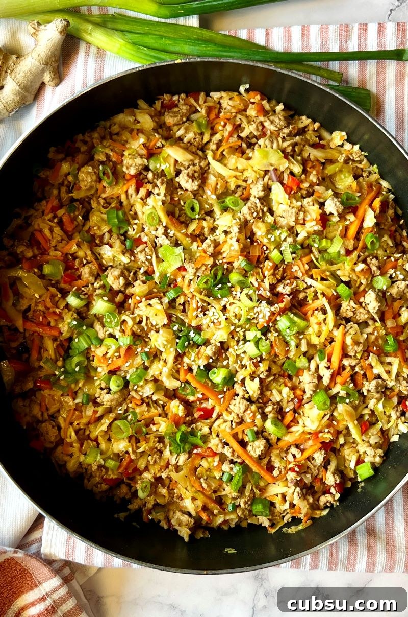 Skillet Egg Roll Bowls with Ground Pork and Veggies 7 One-pan egg roll bowls cooked in pan and topped with green onion slices and sesame seeds.