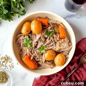 A bowl of roast pork with carrots and potatoes.