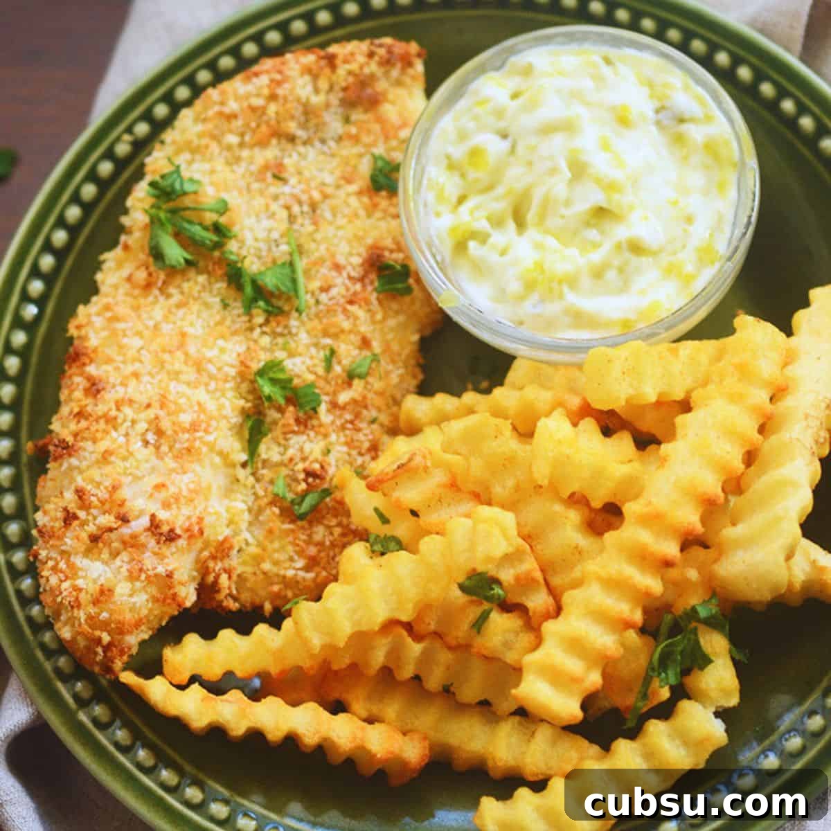 Crispy Air Fryer Fish and Chips Recipe for Perfect Crunch 2 Air Fryer Fish and Chips on a green plate with tartar sauce.