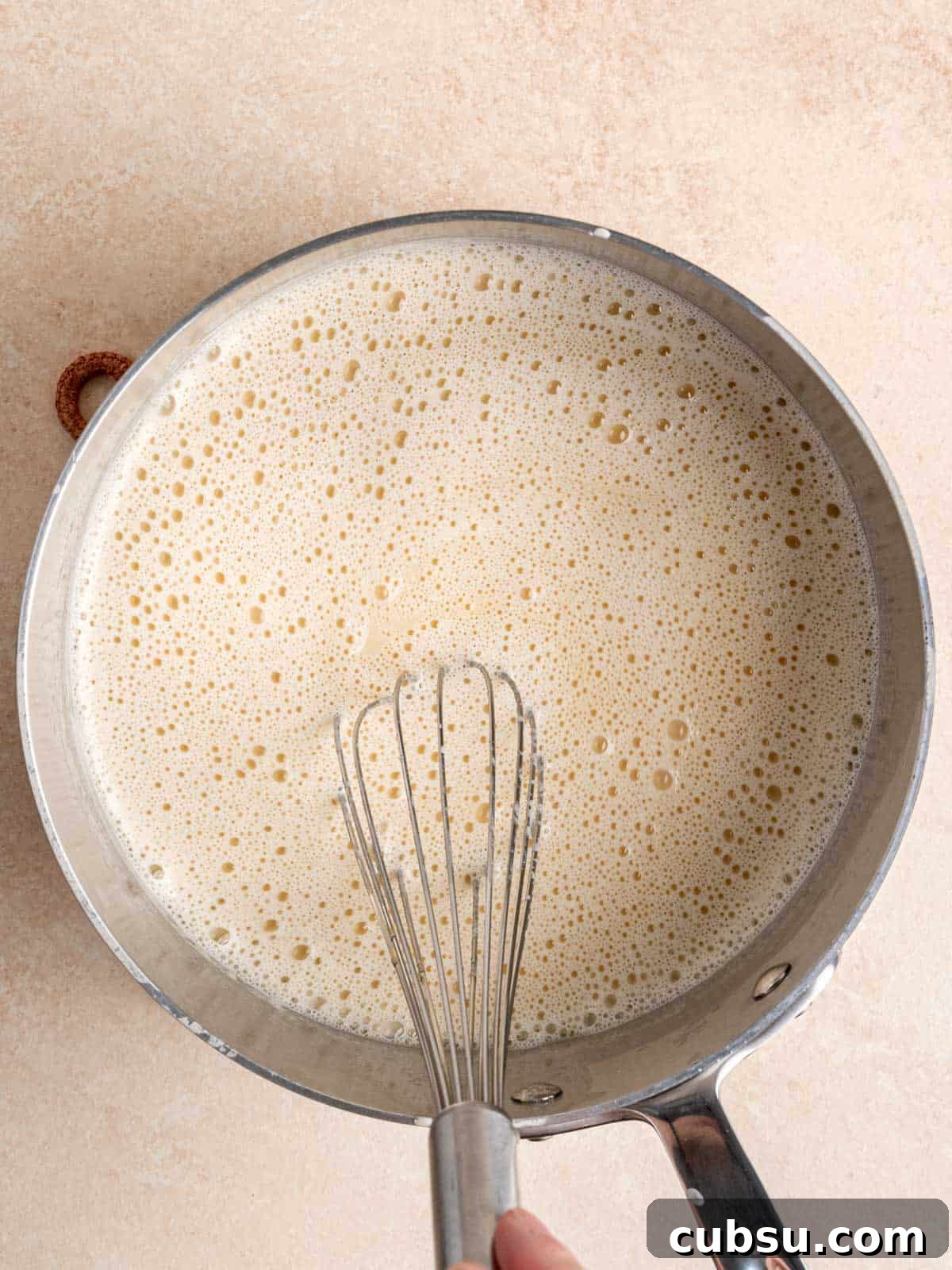 Whisking ice cream mixture in a pot.