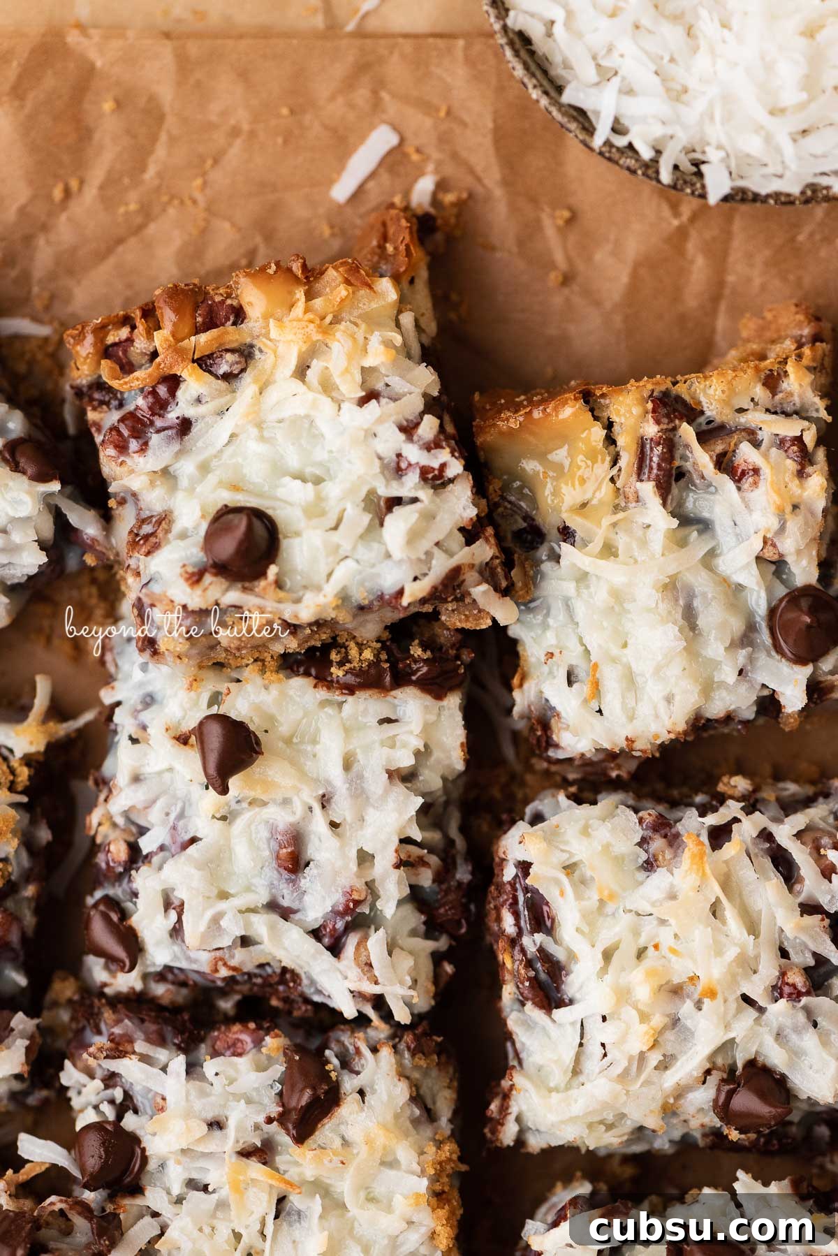 7-Layer Magic Cookie Bars Recipe: Simple Crowd-Pleaser 5 7 layer magic cookie bars on brown parchment paper