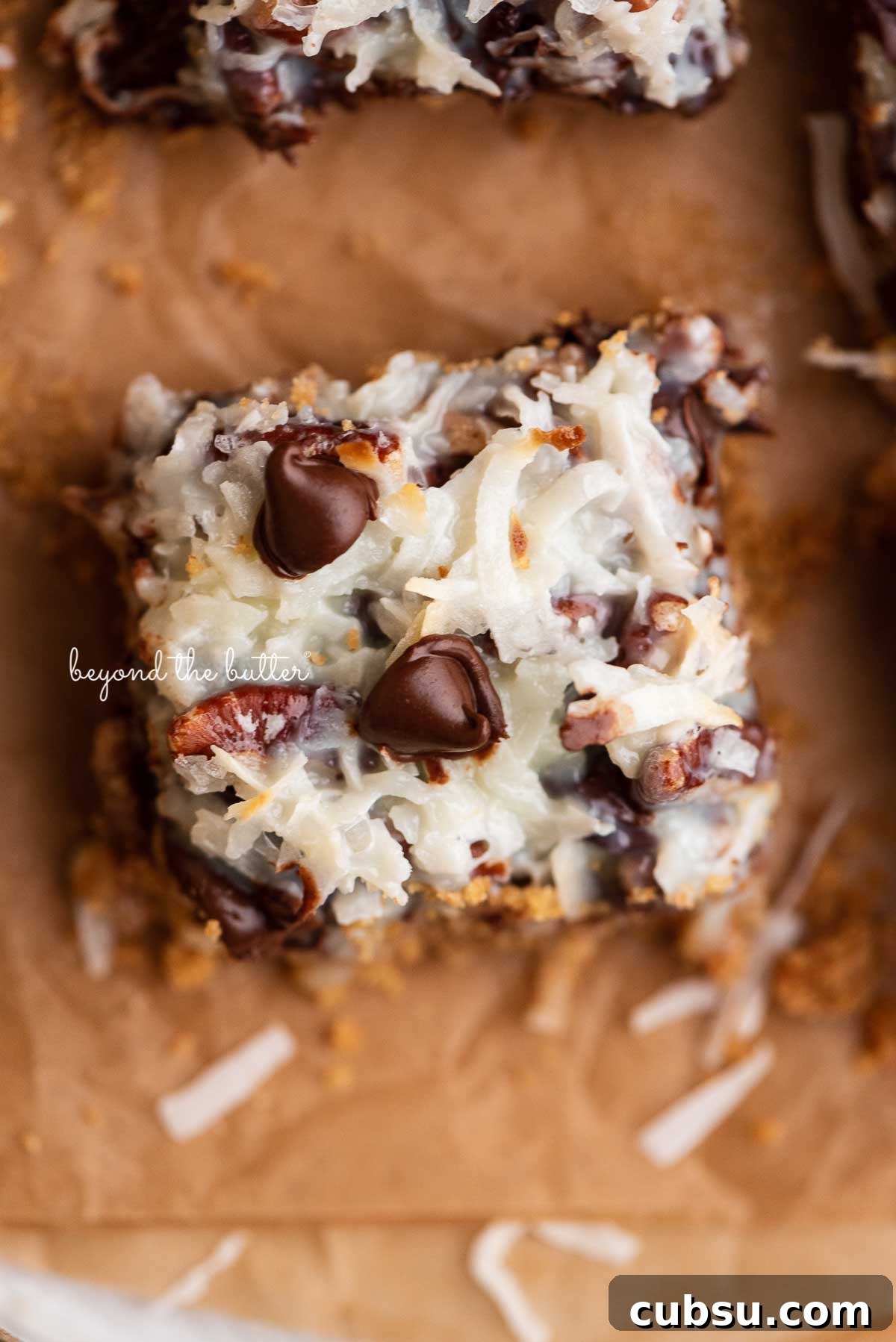 7-Layer Magic Cookie Bars Recipe: Simple Crowd-Pleaser 6 Magic cookie bars on brown parchment paper