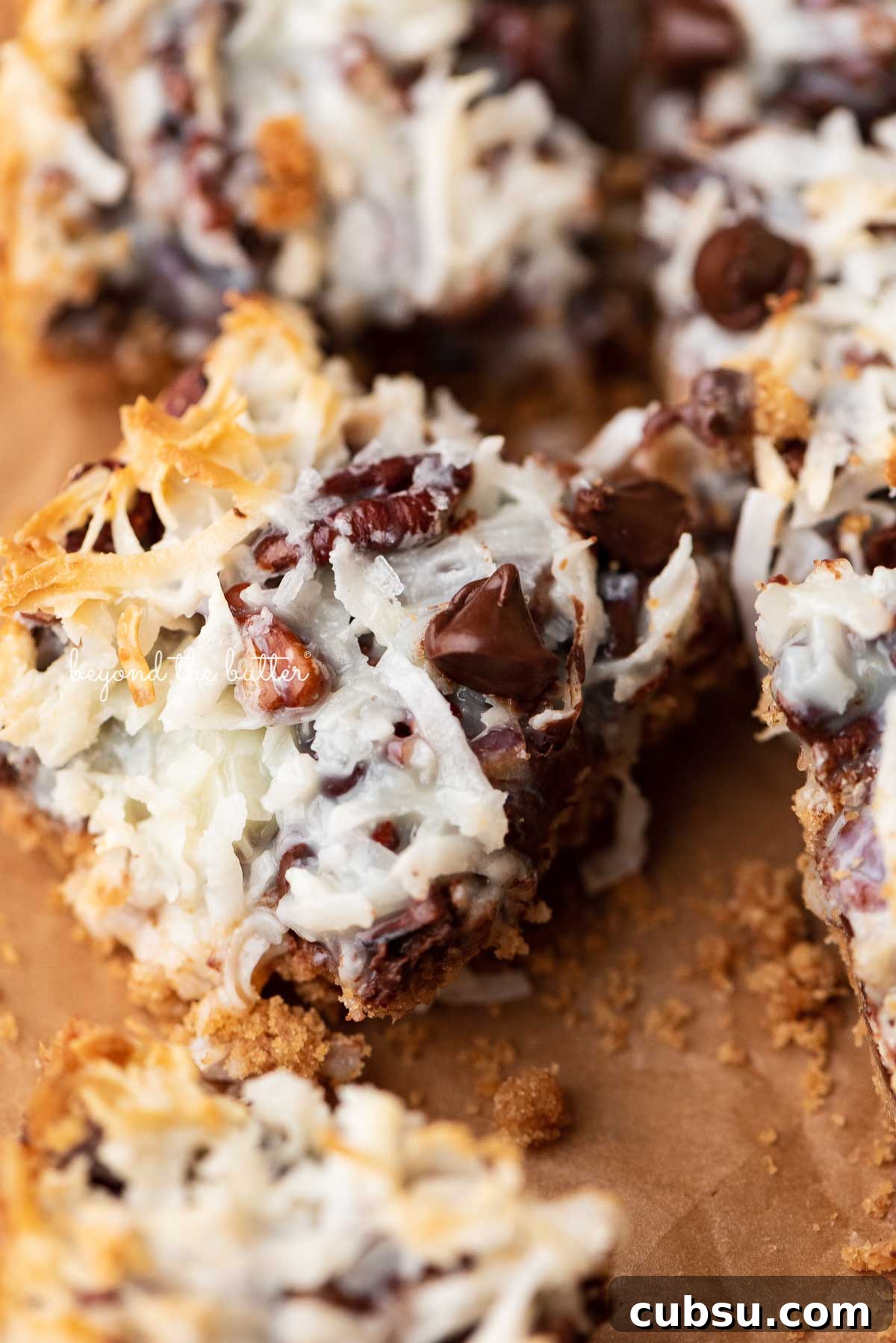 7-Layer Magic Cookie Bars Recipe: Simple Crowd-Pleaser 7 7 layer magic cookie bars on brown parchment paper