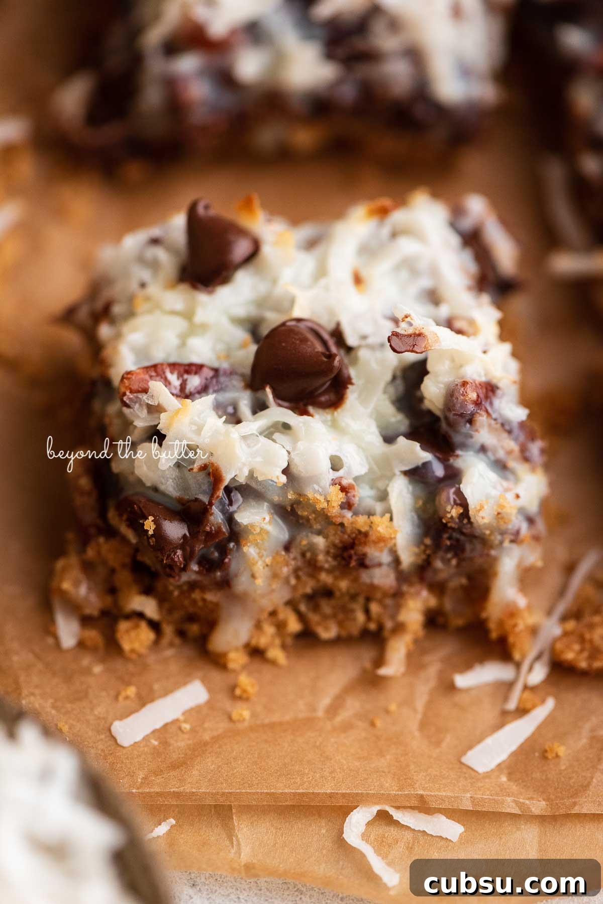 7-Layer Magic Cookie Bars Recipe: Simple Crowd-Pleaser 9 Sliced magic cookie bars on brown parchment paper