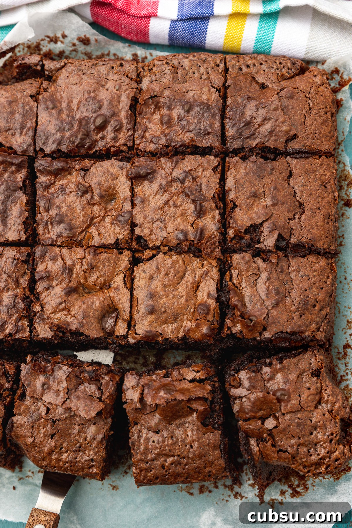 One-Bowl Gluten-Free Brownies: Fudgy Recipe for Chocolate Lovers 7 A pan of sliced brownies from above and with a multi-coloured striped tea towel above it