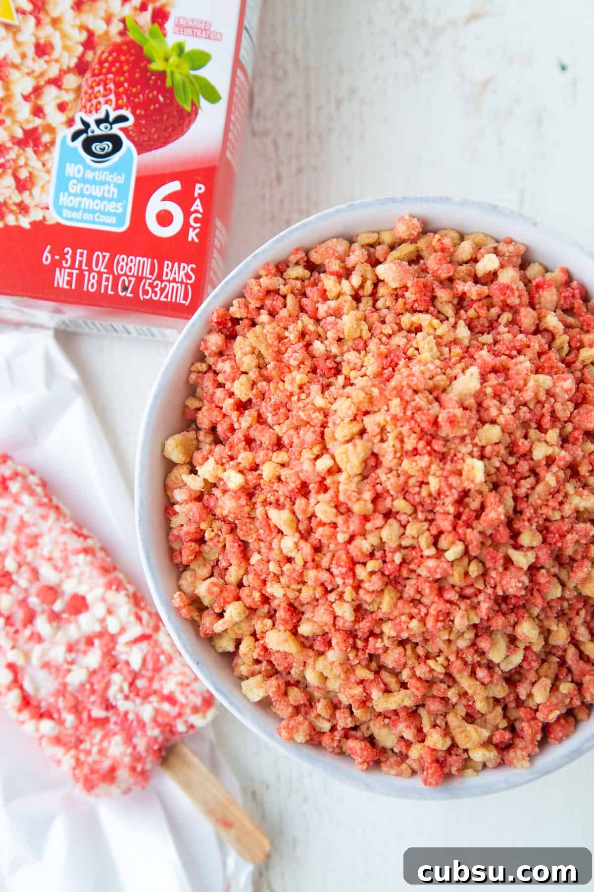 bowl of strawberry crunch next to a box of strawberry shortcake ice cream bars.
