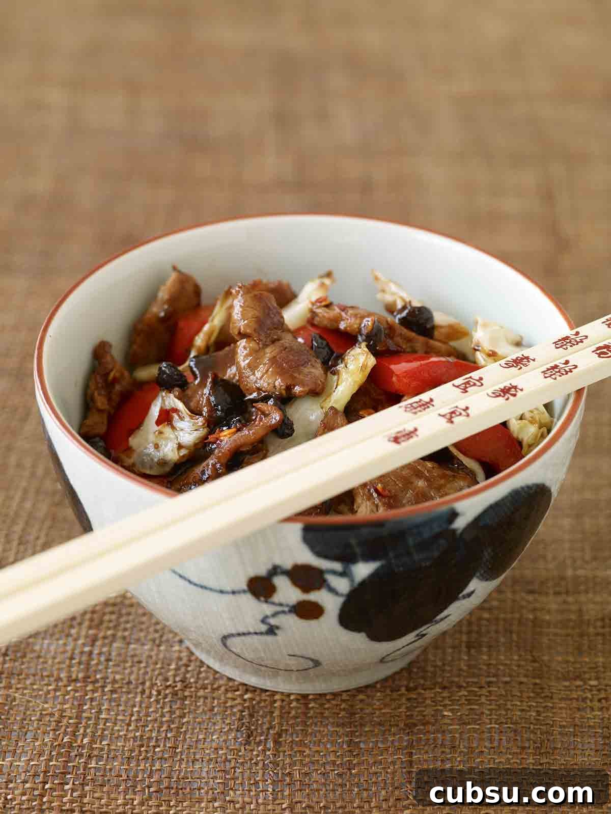 Spicy Chungking Pork in a bowl with chopsticks