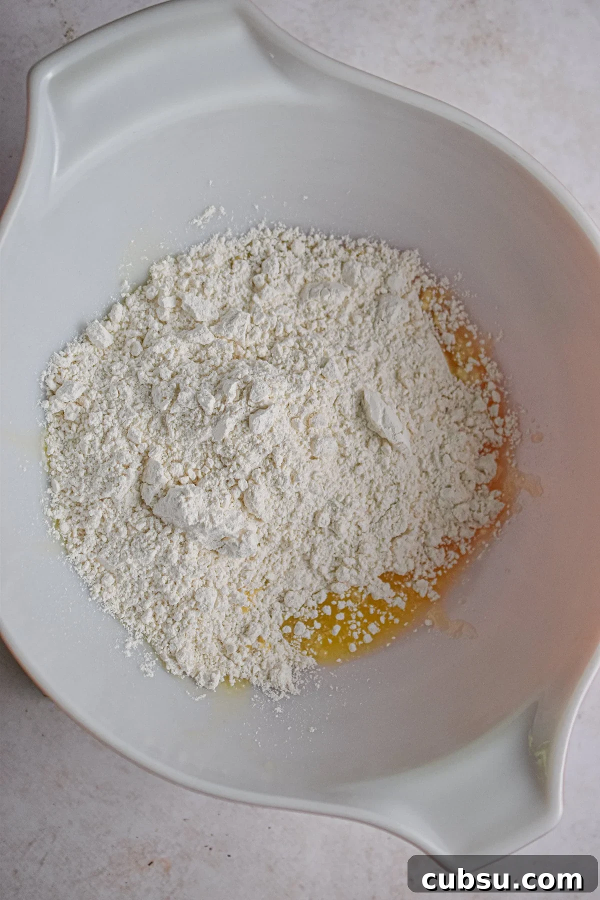 The bisquick and melted butter are added to a large bowl.