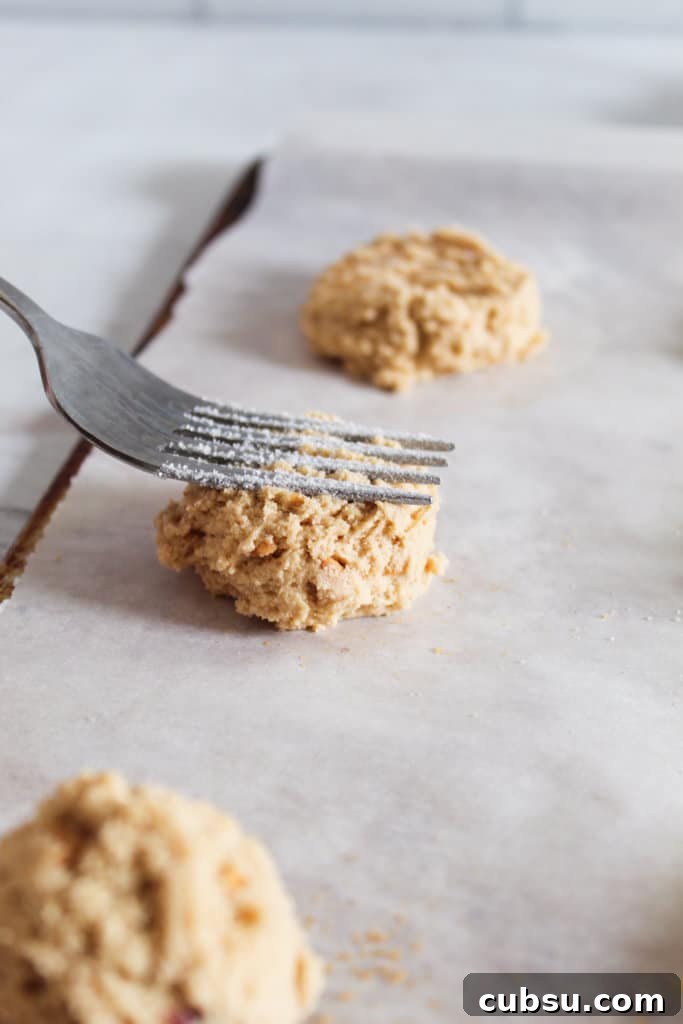 Gluten-Free Peanut Butter Cookies Recipe You’ll Love 6 pressing down peanut butter batter with a fork.