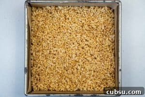 5-Ingredient Rice Krispie Treats Made Without Marshmallows 11 Spreading the mixture into the baking dish