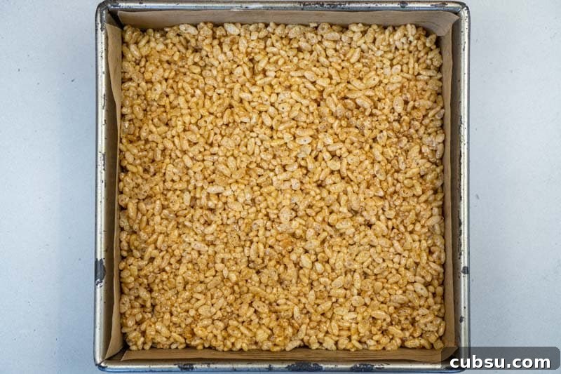 5-Ingredient Rice Krispie Treats Made Without Marshmallows 6 Spreading the mixture into the baking dish