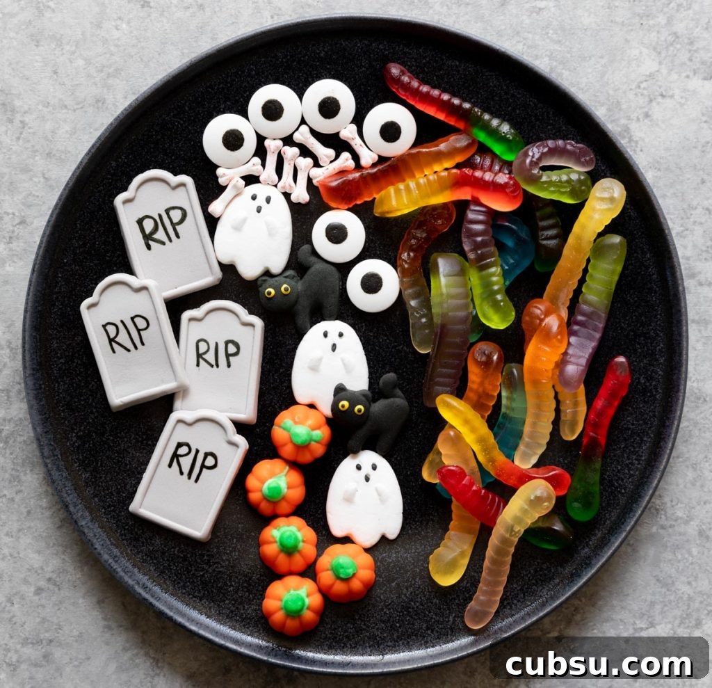 Spooky Halloween Dirt Cups Recipe for Kids and Parties 3 Halloween candy ghosts, pumpkins, tombstones, gummy worms, and eyes
