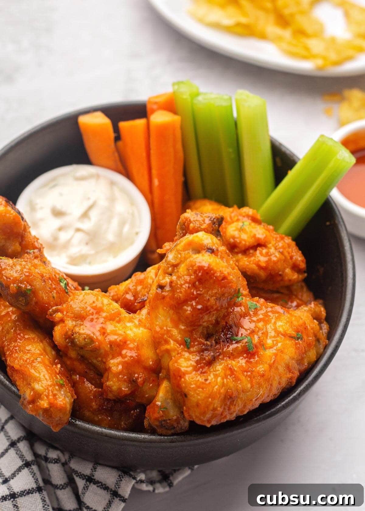 Crispy Buffalo Chicken Wings in the Air Fryer (Quick Recipe) 2 Air Fryer Buffalo Chicken Wings in a bowl with carrots and celery