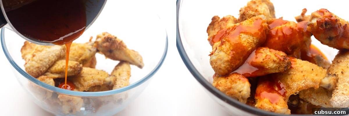 Crispy Buffalo Chicken Wings in the Air Fryer (Quick Recipe) 9 pouring sauce over wings, sauce on wings