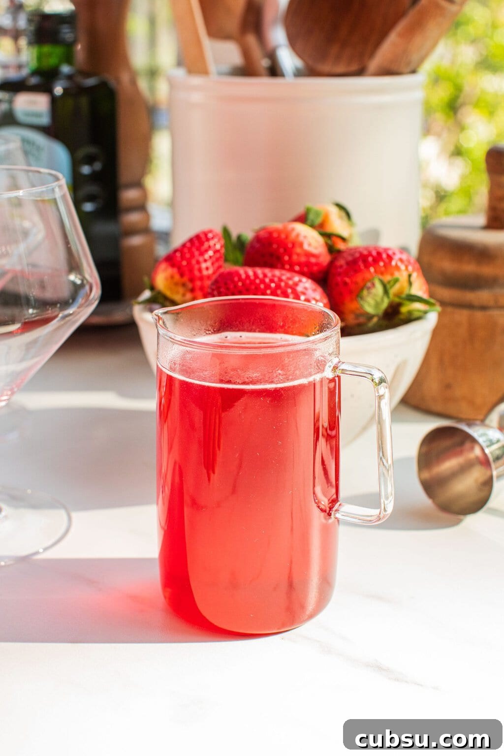 Homemade Strawberry Syrup Recipe for Cocktails and Mixers 9 a small glass pitcher of strawberry simple syrup