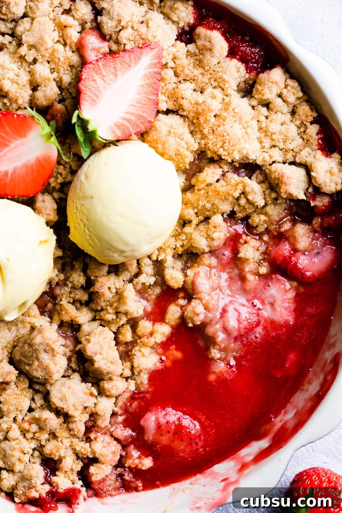 top down close up of a crumble dessert with strawberry sauce underneath