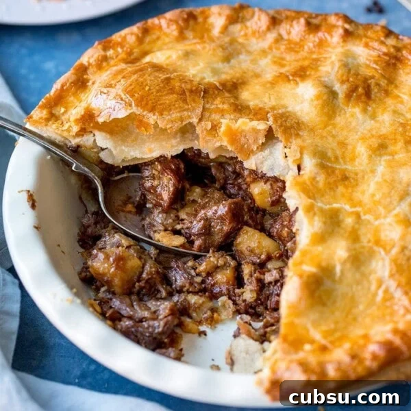 Square image of steak and potato pie with slice taken out