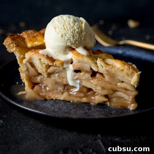 A grey plate with a slice of deep dish apple pie and ice cream.