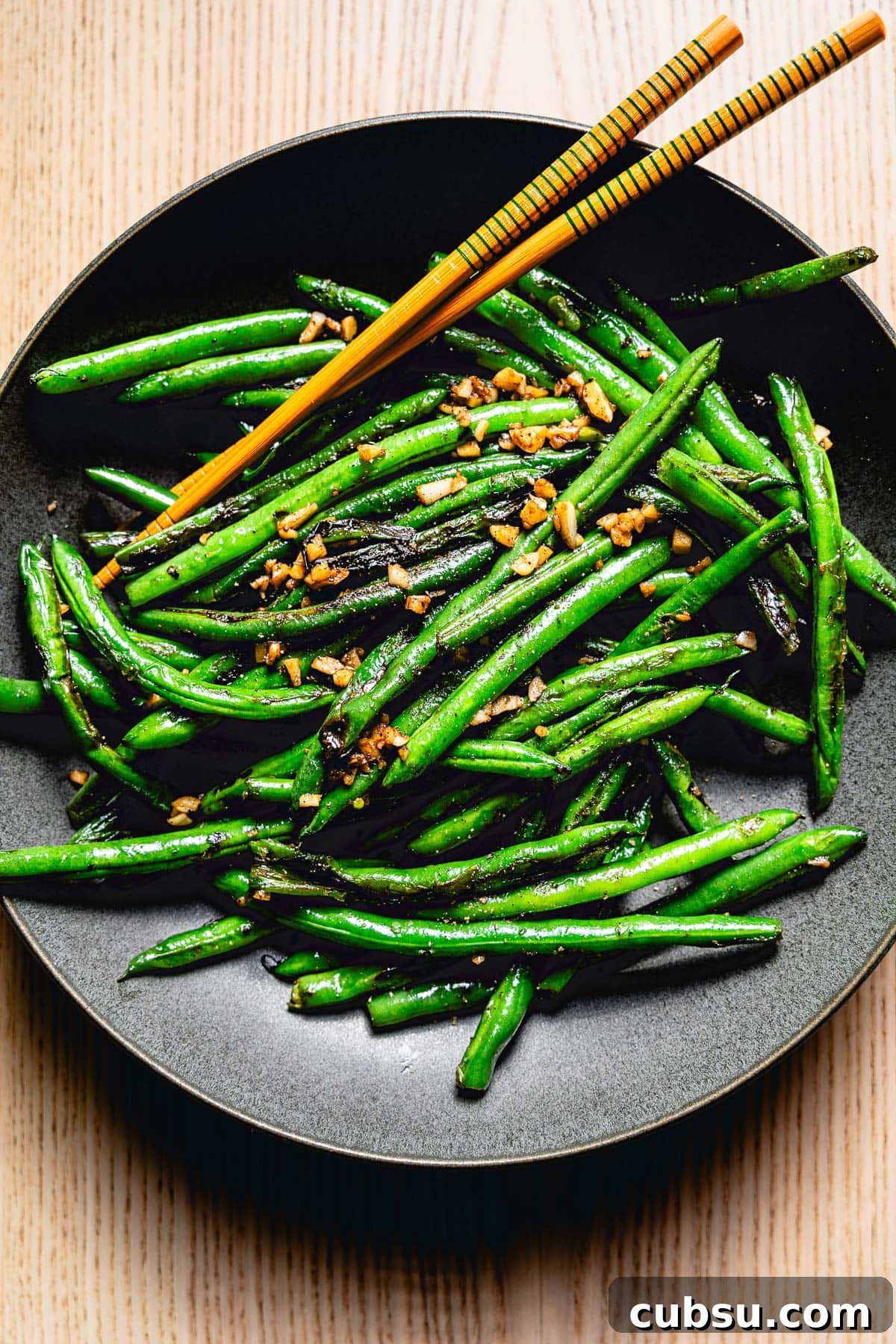 sauteed green beans with garlic on plate overhead