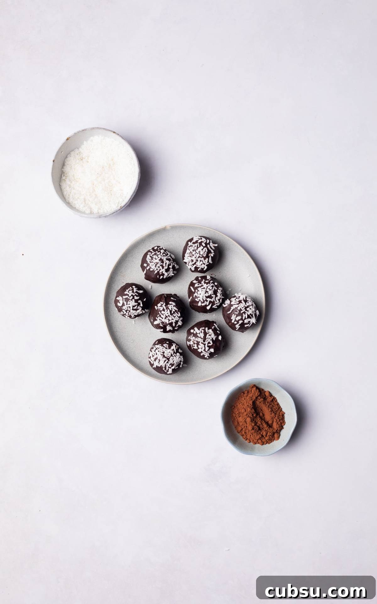 No-Bake Chocolate Coconut Energy Bites 9 Chocolate Coconut Balls served on a plate topped with coconut flakes.