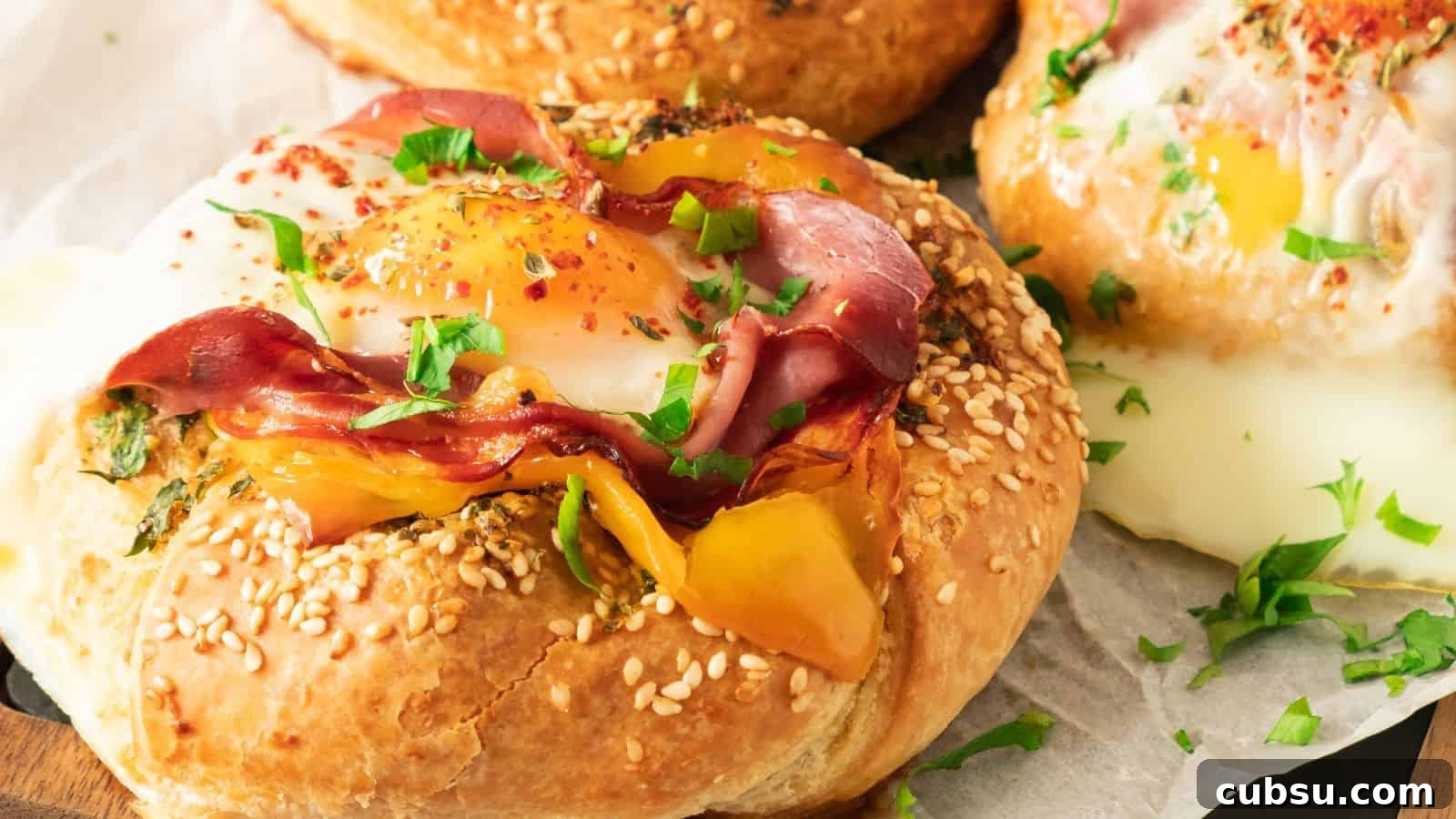 7 Holiday Ham Recipes to Make Dinner Feel Just Right 4 Close-up of a savory pastry topped with a sunny-side-up egg, sliced ham, yellow bell pepper, and garnished with chopped parsley, served on a sesame seed bun.